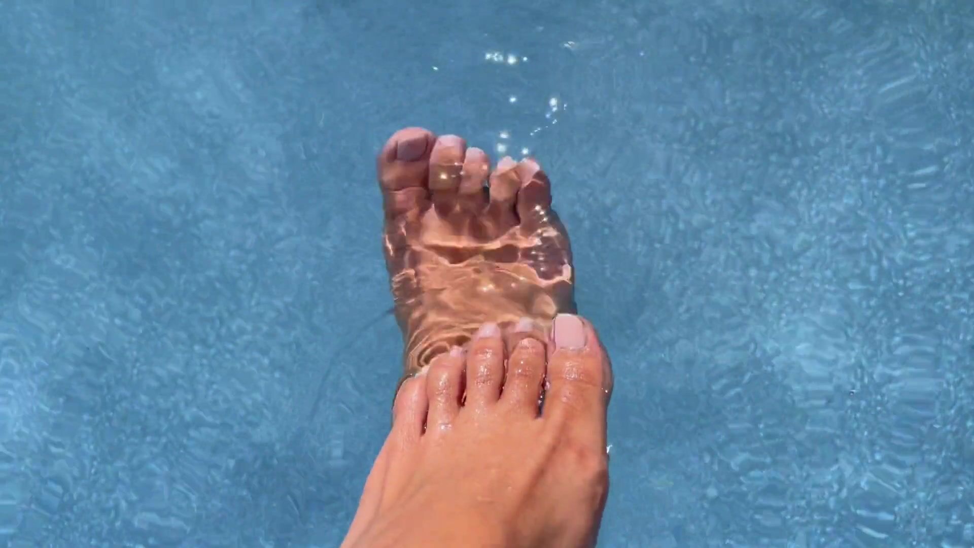 Paula Shy splashing feet in the water.